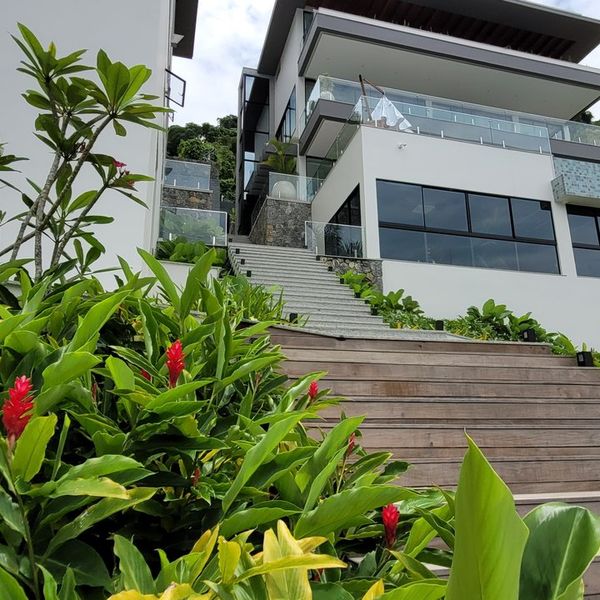 Fachada com escadaria e jardim tropical